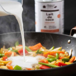lait de coco dans un wok de légumes